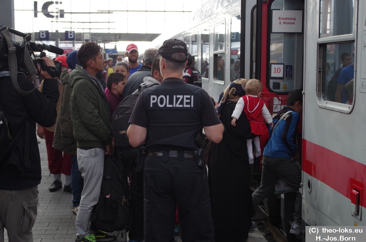 Polizisten beobachten den Umstieg der Flüchtlinge